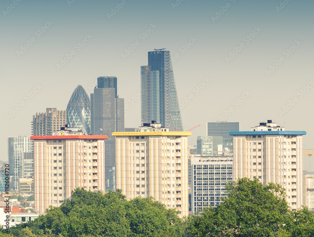 City of London skyline over green trees
