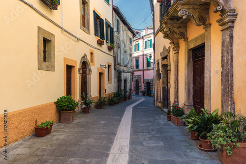 Spring streets of the old Tuscan town. Colorful flowers bloom an #112604929