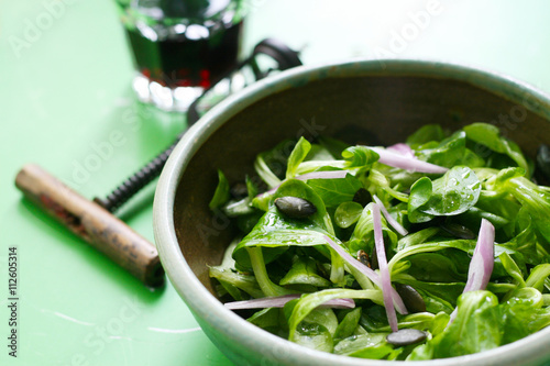 Leichte Vorspeise, Feldsalat mit Schalotten, Kürbiskernen - Regionale Salate der Saison mit einem Glas Rotwein photo