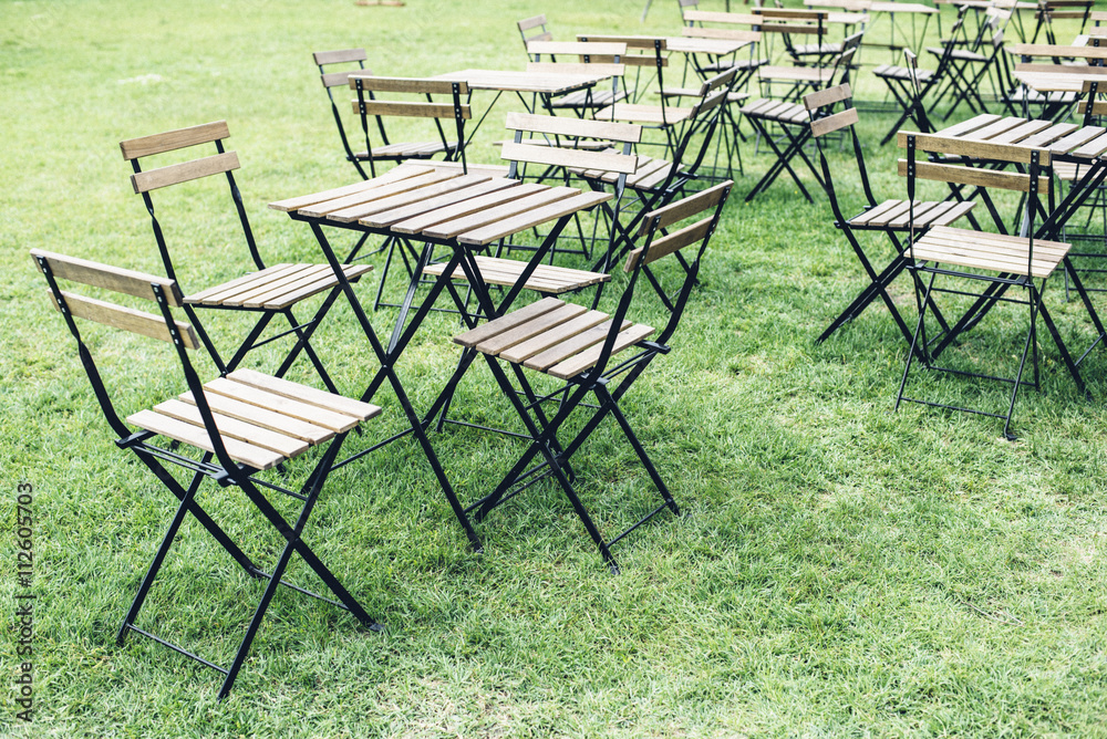 Empty tables and chairs standing on grass in summer cafeteria Empty tables and chairs standing on grass in summer cafeteria