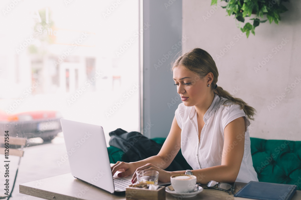 She is always in business. Woman working on laptop in cafe bar on her coffee break. She is always in business. Woman working on laptop in cafe bar on her coffee break.