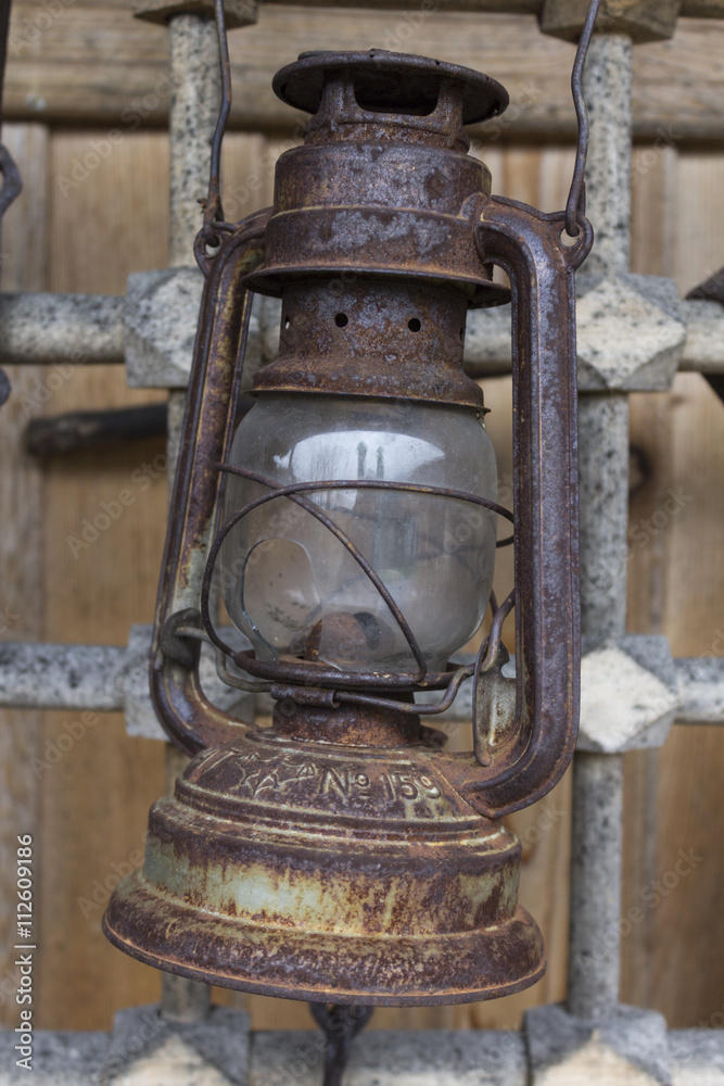 Old kerosene lamp hanging on a metal grid