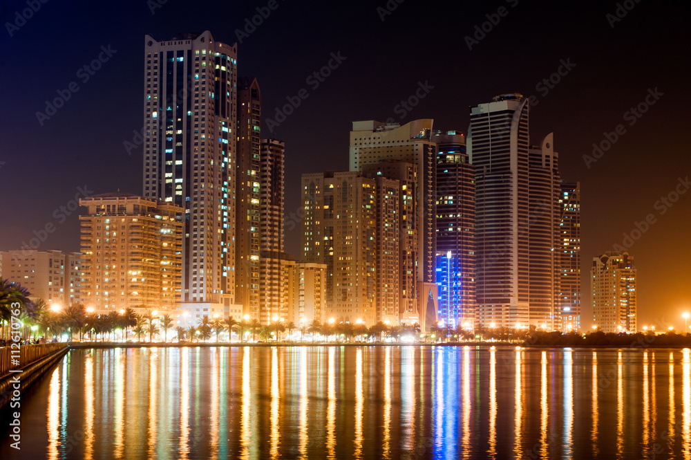 Night cityscape of Sharhaj with reflection in the gulf, UAE