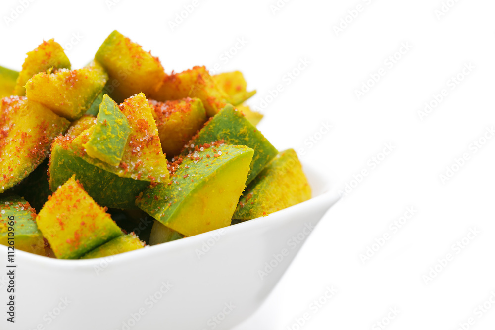 Organic sliced Indian Mango (Mangifera indica), seasoned with turmeric, salt and red chili pepper in white bowl. Isolated on white background. Front view. Organic sliced Indian Mango (Mangifera indica), seasoned with turmeric, salt and red chili pepper in white bowl. Isolated on white background. Front view.