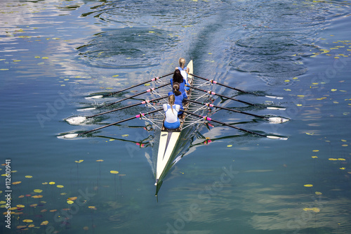 Four women rowing on the tranquil lake