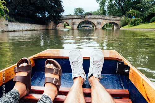 Man and woman feet on a boat punting in the river in  Cambridge. Focus on feet. photo