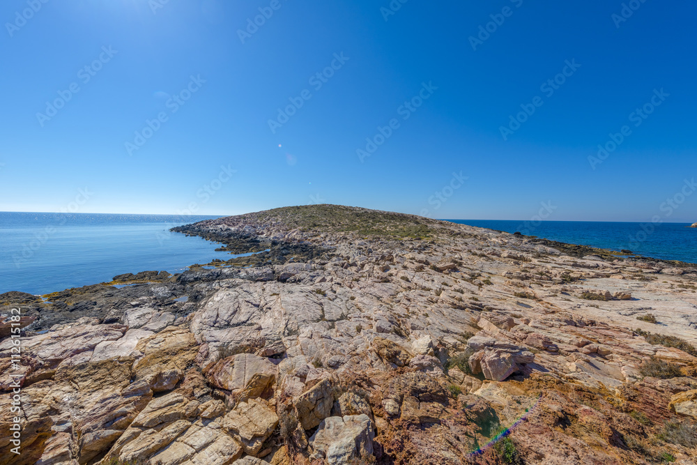 Rocky beach in Mykonos, Cyclades, Greece. Rocky beach in Mykonos, Cyclades, Greece.