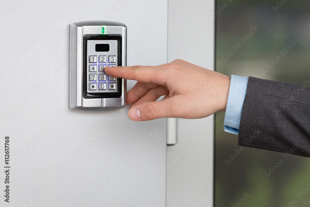 Close up of businessman hand entering security system code Close up of businessman hand entering security system code