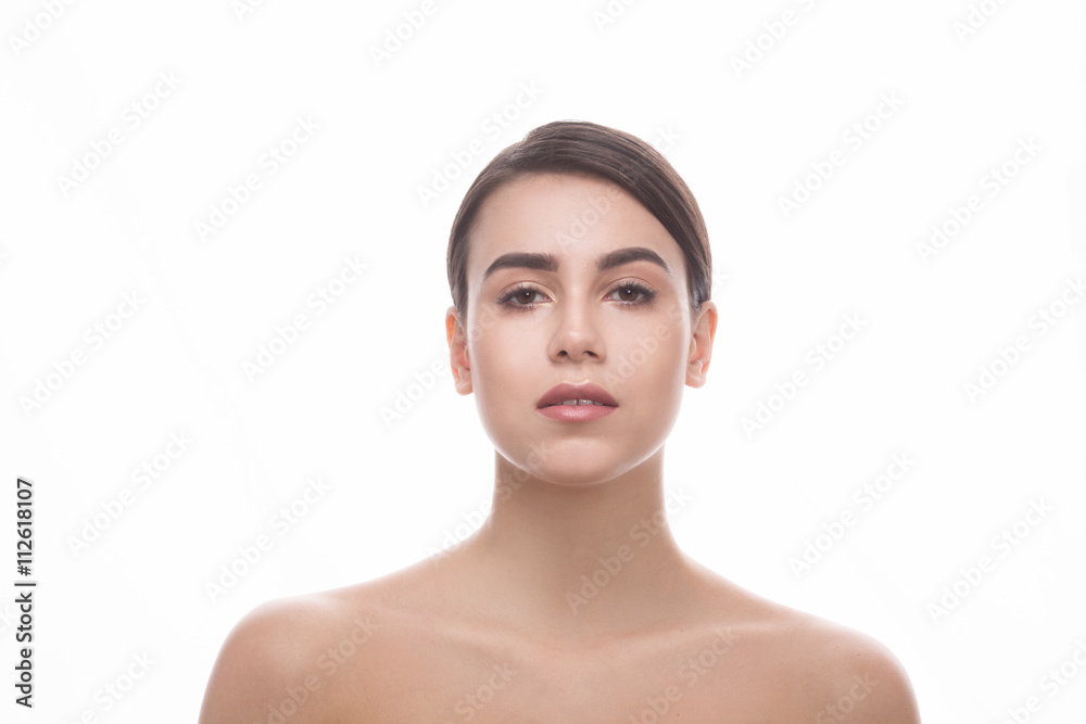 Young brunette lady over white background. Portrait of beautiful woman looking at camera and demonstrating her perfect shoulders. Young brunette lady over white background. Portrait of beautiful woman looking at camera and demonstrating her perfect shoulders.