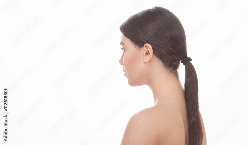 Portrait of beautiful young woman posing in studio. Pretty lady with long hair showing her elegant and gorgeous back over white background. Portrait of beautiful young woman posing in studio. Pretty lady with long hair showing her elegant and gorgeous back over white background.