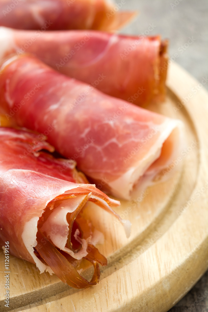 Spanish serrano ham on rustic wood