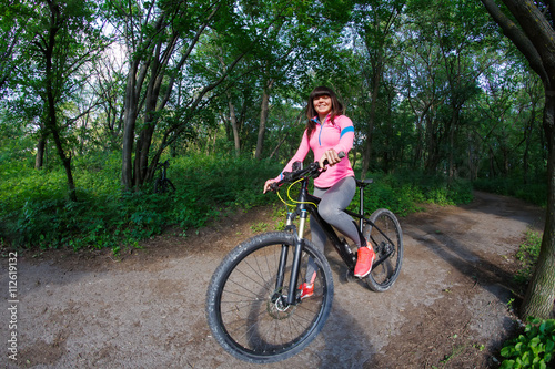 Young woman having fun riding a bicycle in the park.