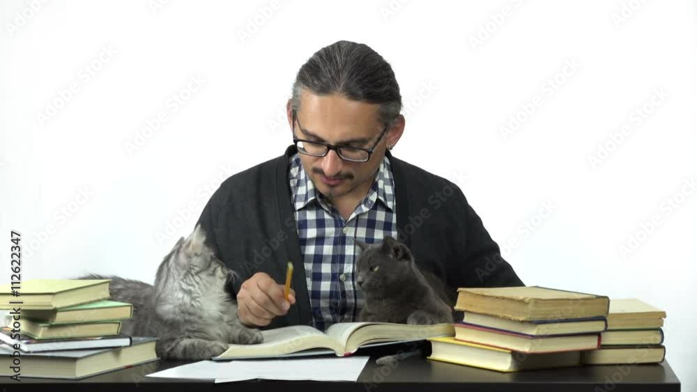 man sitting at table studying and writing in notebook. his cats are looking at him. 4k people stock footage clip at white background.
man sitting at table studying and writing in notebook. his cats are looking at him. 4k people stock footage clip at white background.