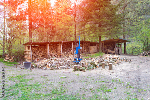 Log splitter in the middle of a rural scene with wood and forest photo
