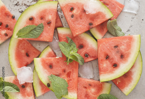 Watermelon slices with ice cubes and mint, top view