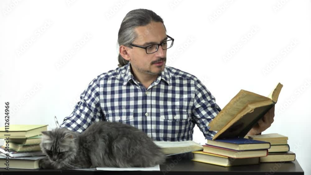 man sitting at table studying and writing in notebook. his cats are looking at him. 4k people stock footage clip at white background.
man sitting at table studying and writing in notebook. his cats are looking at him. 4k people stock footage clip at white background.