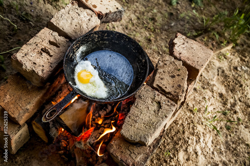 egg is fried in a cast iron skillet on fire