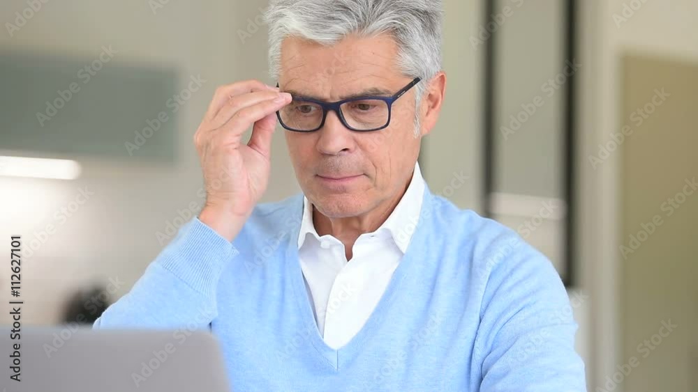 Senior man with eyeglasses using laptop computer Senior man with eyeglasses using laptop computer