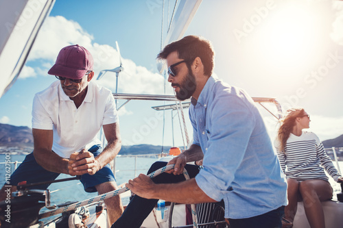 Two men preparing to set sail on yacht photo