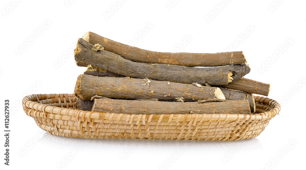 Liquorice roots in basket on white background