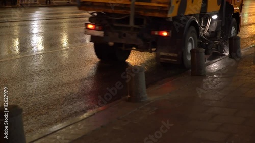 Water tank truck with sweeper cleaning the streets. photo