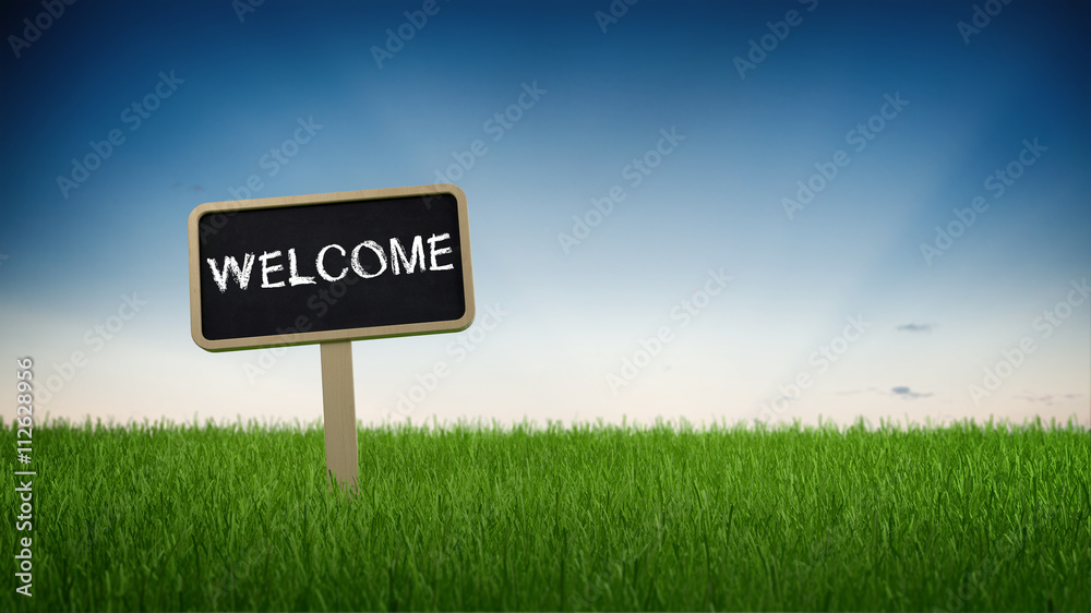 Welcome signboard on a green grassy field