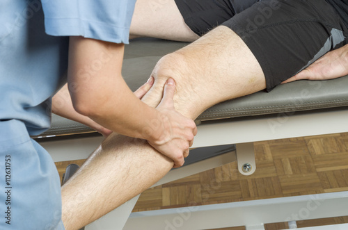 Chiropractor /physioterapist doing a knee massage
