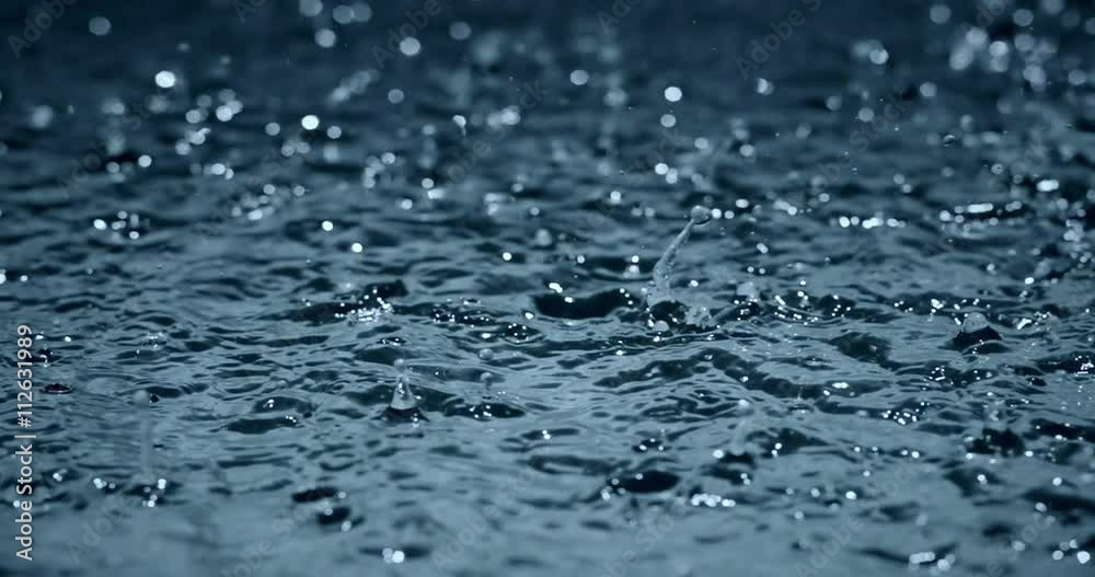 slow motion heavy rain water drops on surface street, seamless loop ready 4K