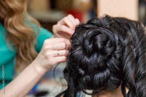 evening hairstyle. brunette doing hairdresser and styling in barber salon