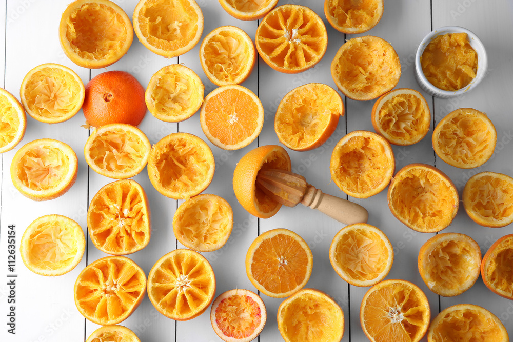 Juicing delicious oranges on white wooden table Juicing delicious oranges on white wooden table