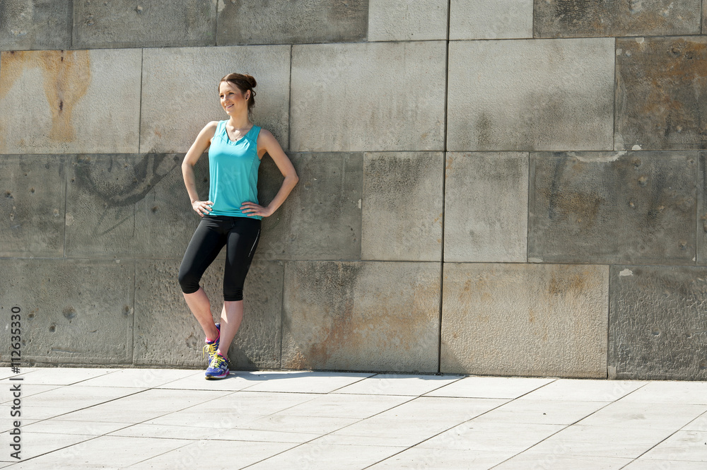 Fit woman resting after run in the city. Jogger. Fit woman resting after run in the city. Jogger.