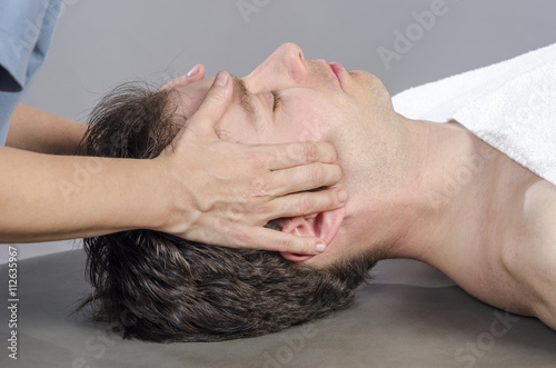 Chiropractor /physioterapist  assessing the muscles on a jaw
