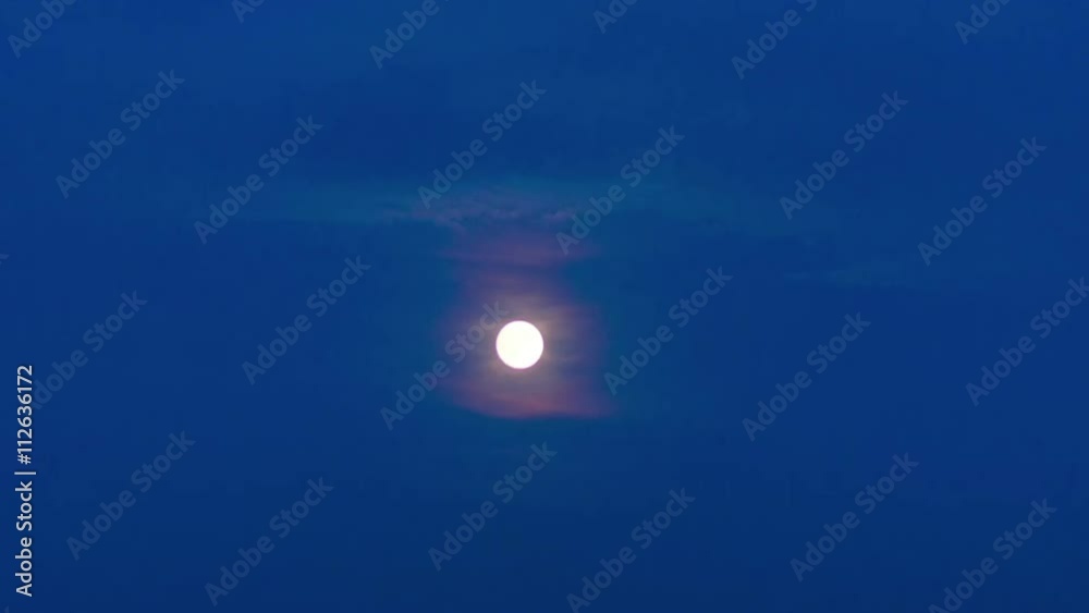 time lapse of the full moon passing through the moving evening clouds in the blue sky getting gradually dark time lapse of the full moon passing through the moving evening clouds in the blue sky getting gradually dark