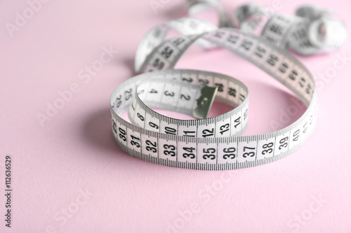 Measuring tape on pink background