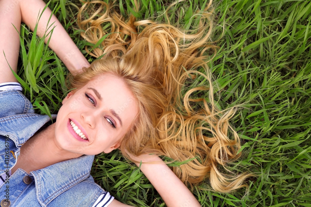 Naklejka premium Young beautiful woman on green grass