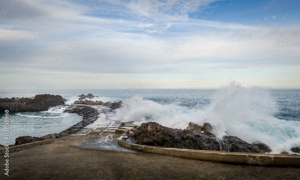 Waves splashing of pier to the Atlantic ocean in Seixal, Madeira island