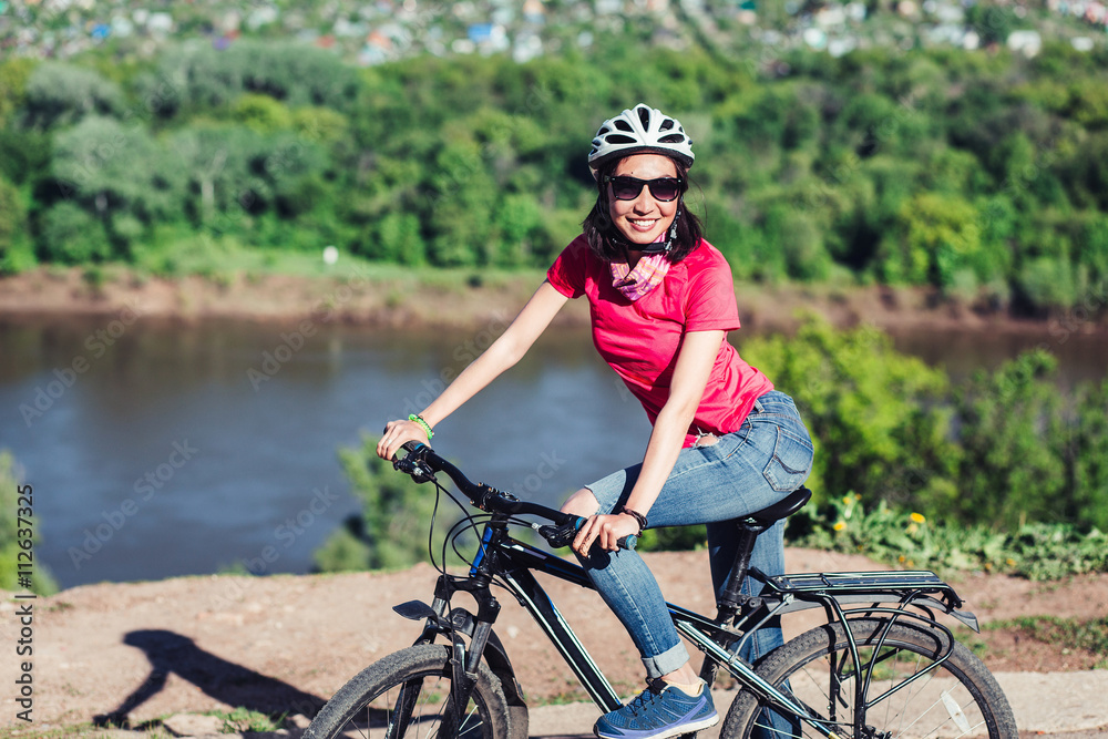 A happy healthy Eastern woman or girl riding her bicycle on a sunny day
