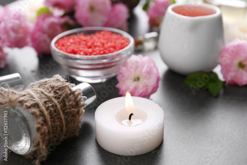 Spa composition with beautiful flowers and aroma oil on the table  close up