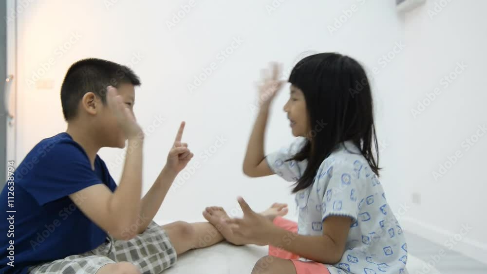 A young girl of Asian ethnicity is jubilant when she beats her brother at 'rock, paper, scissors' A young girl of Asian ethnicity is jubilant when she beats her brother at 'rock, paper, scissors'