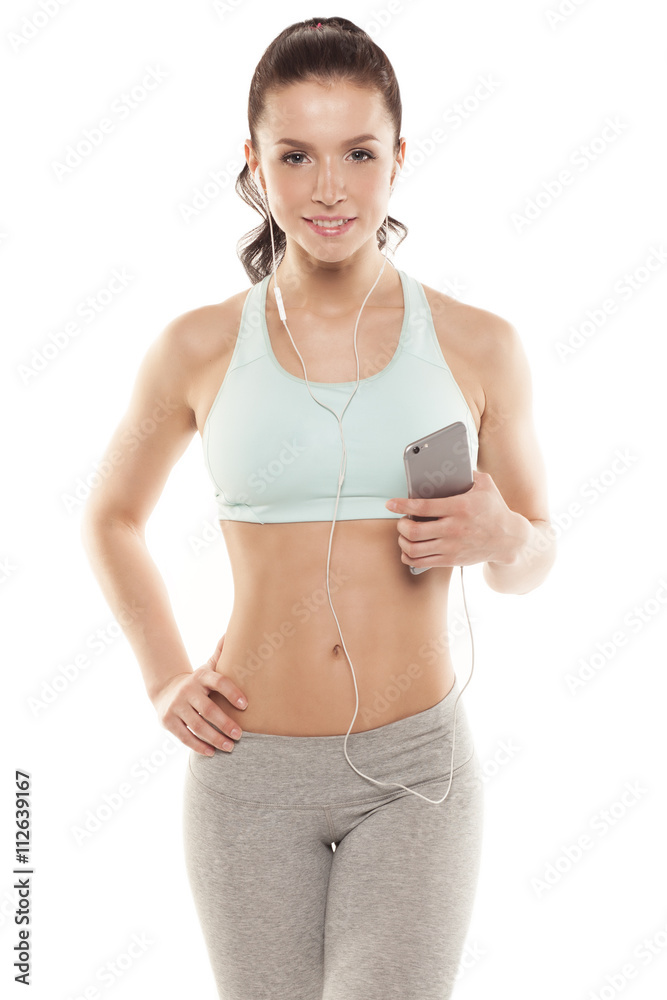 fitness girl with a smartphone on a white background, enjoys sports training, gym workout fitness girl with a smartphone on a white background, enjoys sports training, gym workout