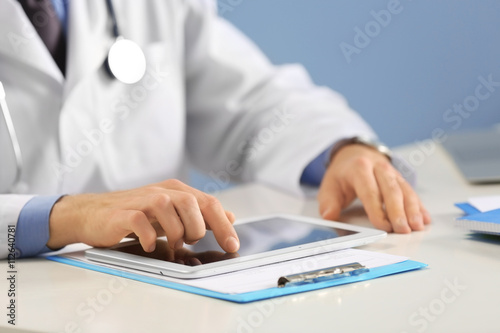 Doctor working on a tablet ...