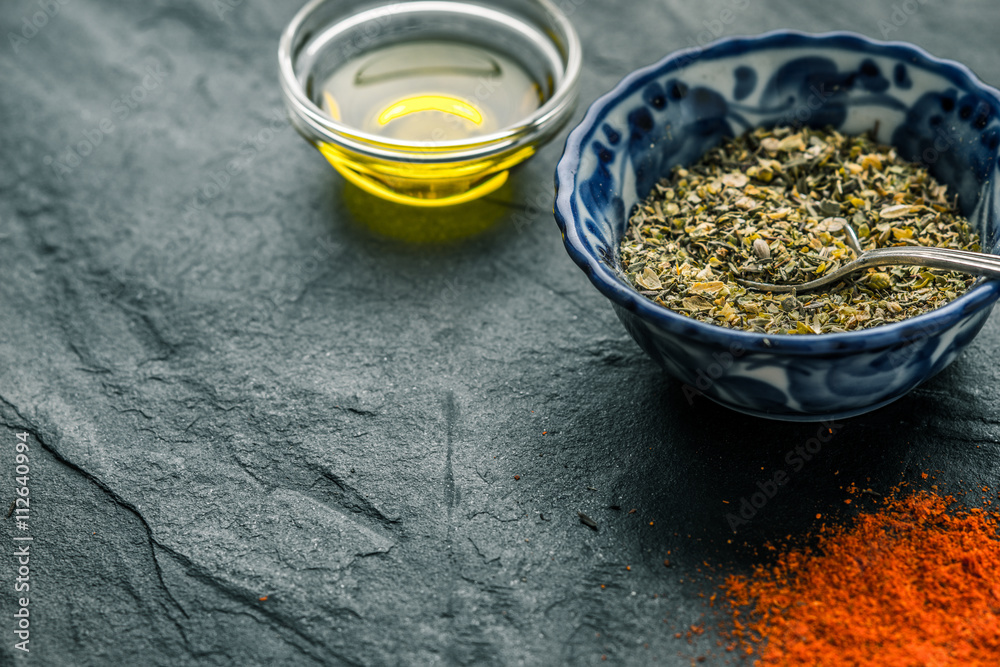 Fototapeta premium Mixture of spices, chilli, olive oil black shale from the right