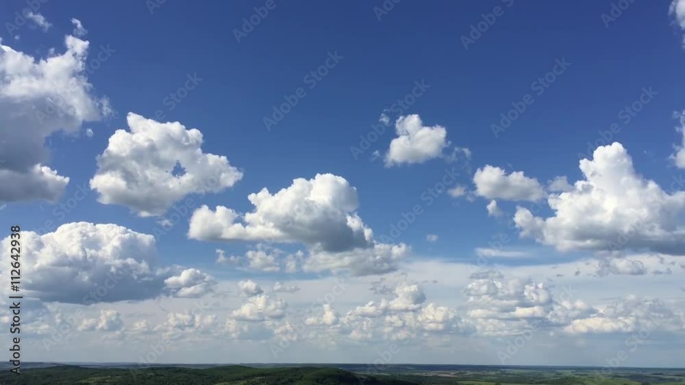 Loop of white clouds over blue sky with God Rays - time lapse