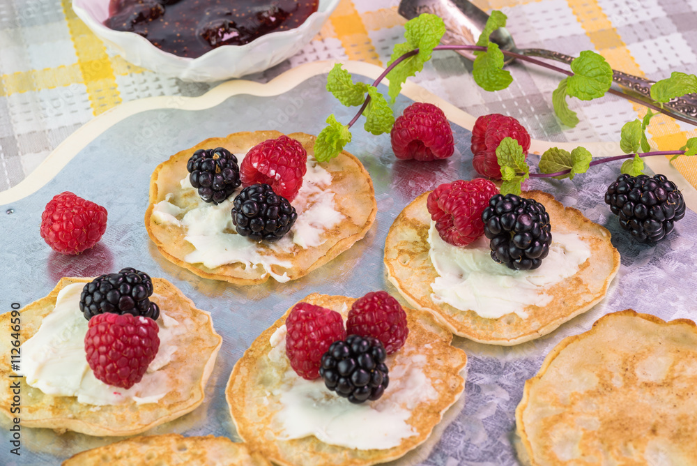 Cornmeal cakes garnish with fresh berries and bowl of berry fig Cornmeal cakes garnish with fresh berries and bowl of berry fig