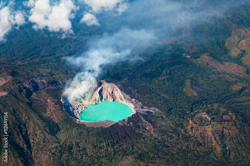 Aerial photo of active volcano Ijen in East Java - largest highly acidic crater lake in world with turquoise sulphuric water. Place of sulfur mining. Famous travel destinations of Indonesian islands.