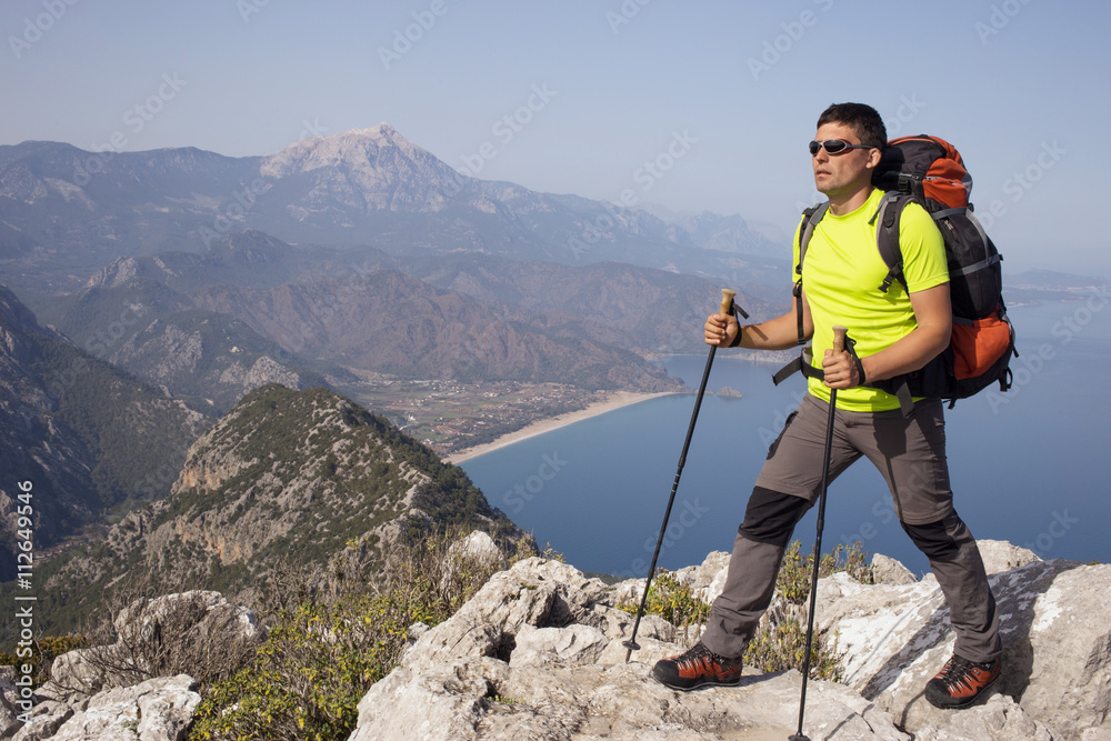 Young man with backpack on a mountain top.