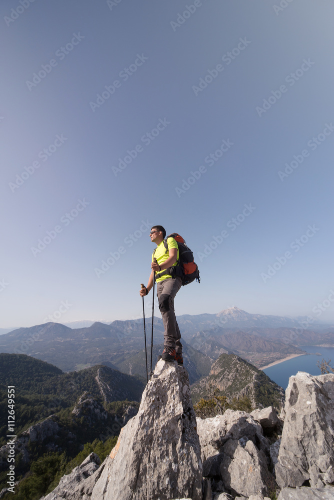Young man with backpack on a mountain top.