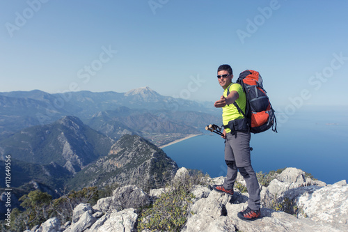 Young man with backpack on a mountain top .