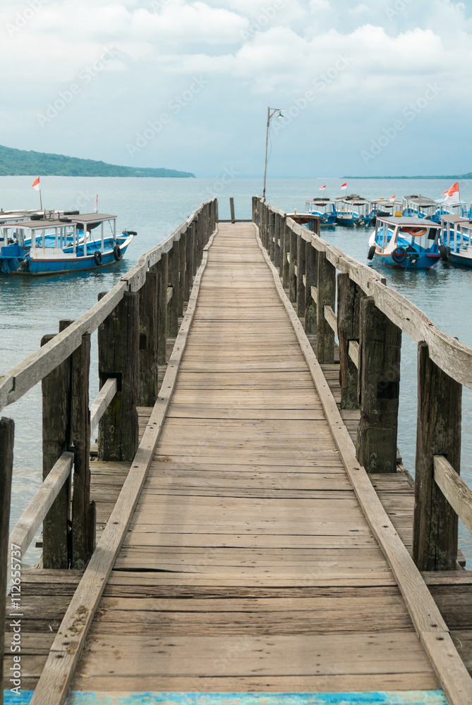 Wooden pier with Balinese boats near Taman Barrat National Park,