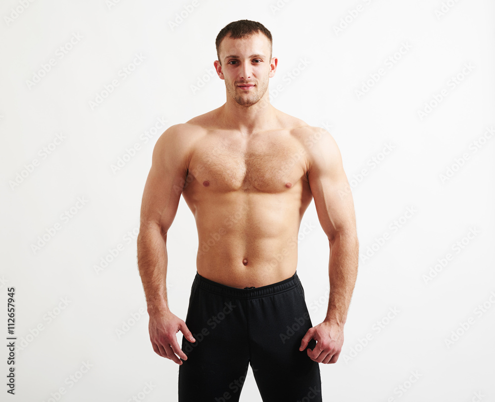 Obraz premium Bare-chested young athletic man over white background